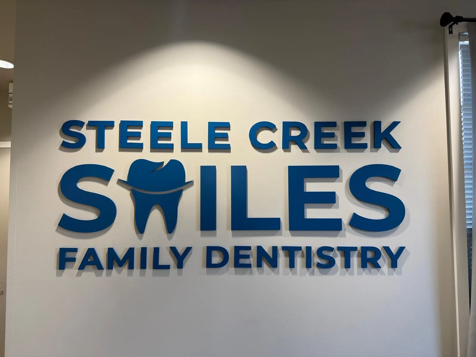 Framed dental veneer samples displayed on a wall at Steele Creek Smiles